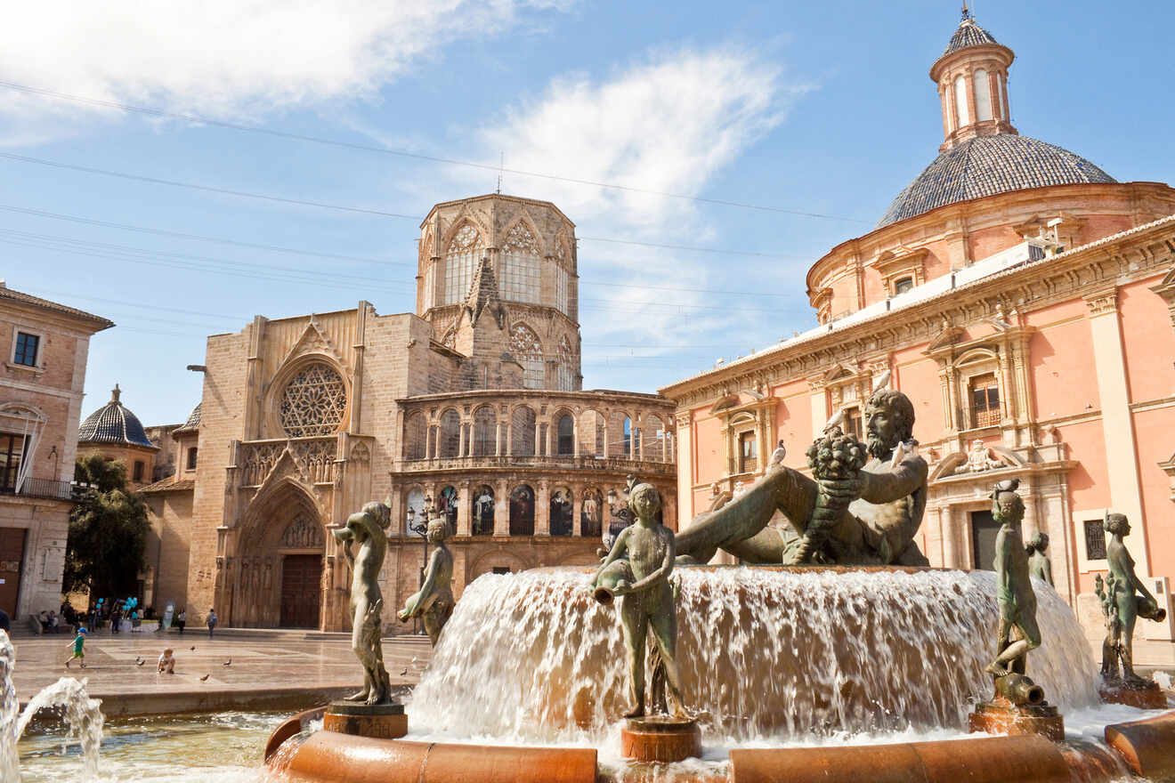 The historic Turia fountain in front of the Valencia Cathedral, with sculptures of Neptune and aquatic creatures, set against the backdrop of the Gothic architecture of the cathedral and the bustling city square.