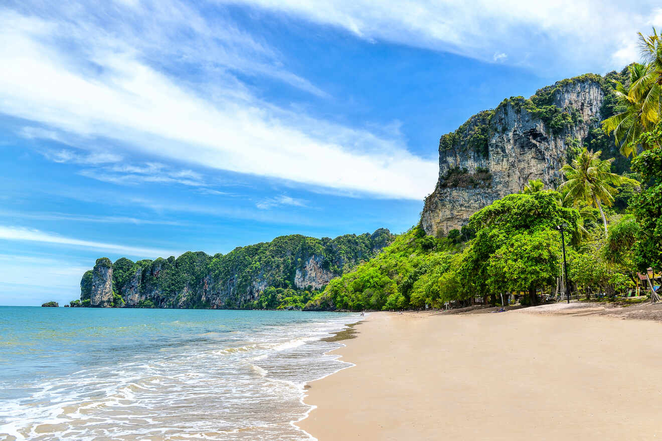 Idyllic beach landscape showcasing soft sandy shores lined with lush greenery and dramatic limestone cliffs, with waves gently lapping at the beach