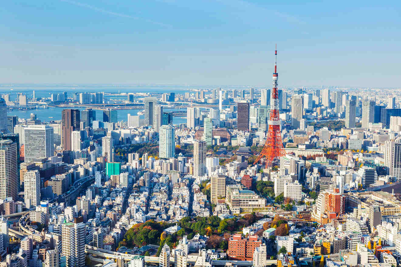 Panoramic view of Tokyo cityscape showing dense urban areas with the Tokyo Tower standing prominently amidst the skyline on a clear day.