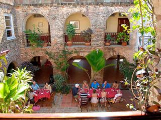 Courtyard dining in a colonial archway building surrounded by lush greenery