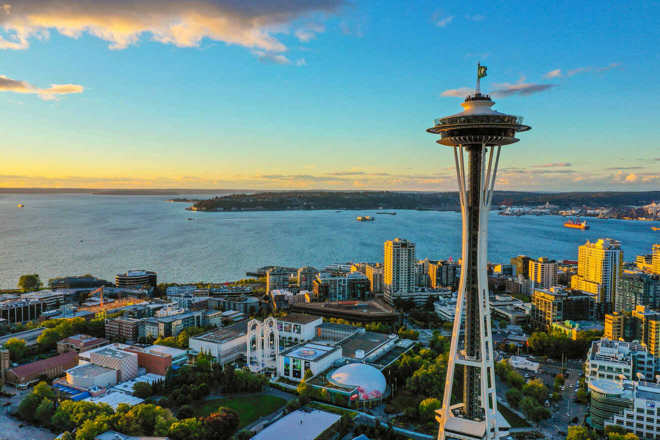 Aerial view of Seattle skyline with the iconic Space Needle standing tall against a backdrop of the city and Puget Sound during golden hour.