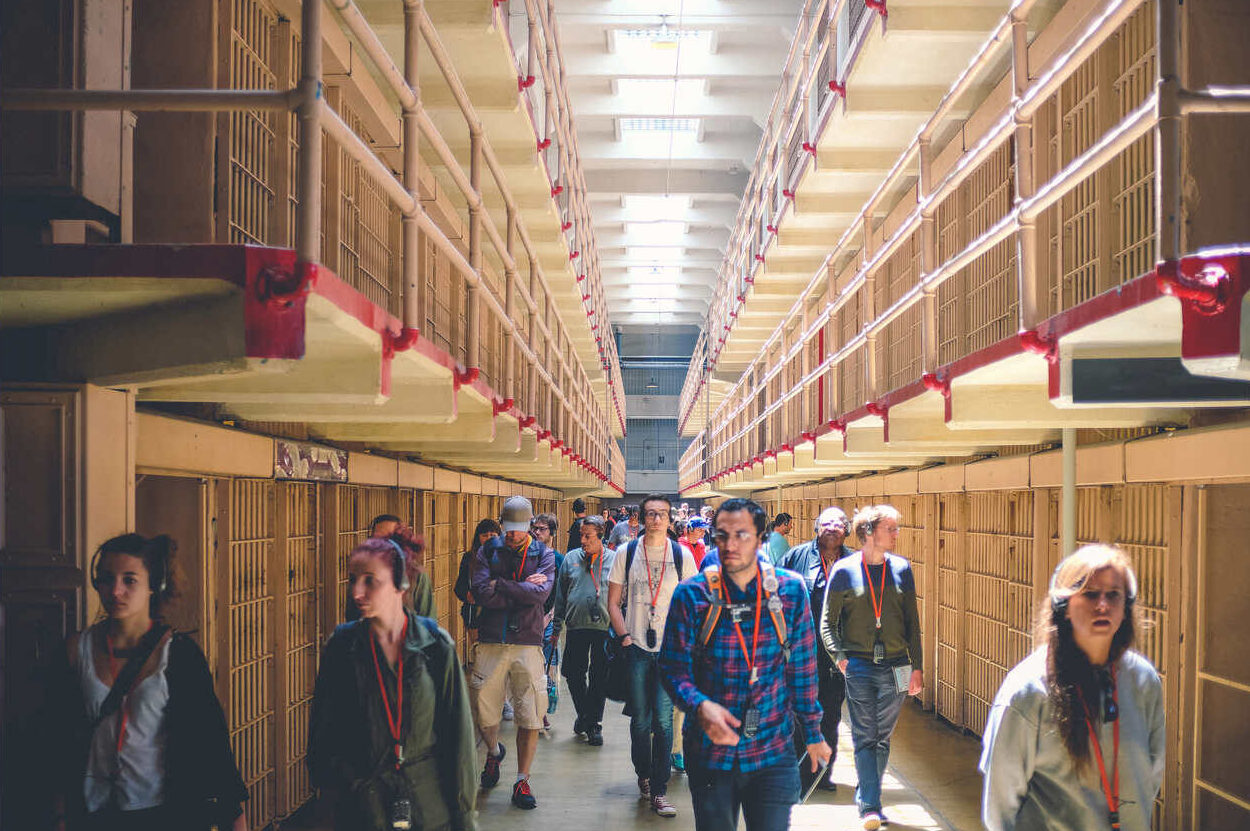 people walking past prison cells at Alcatraz Island