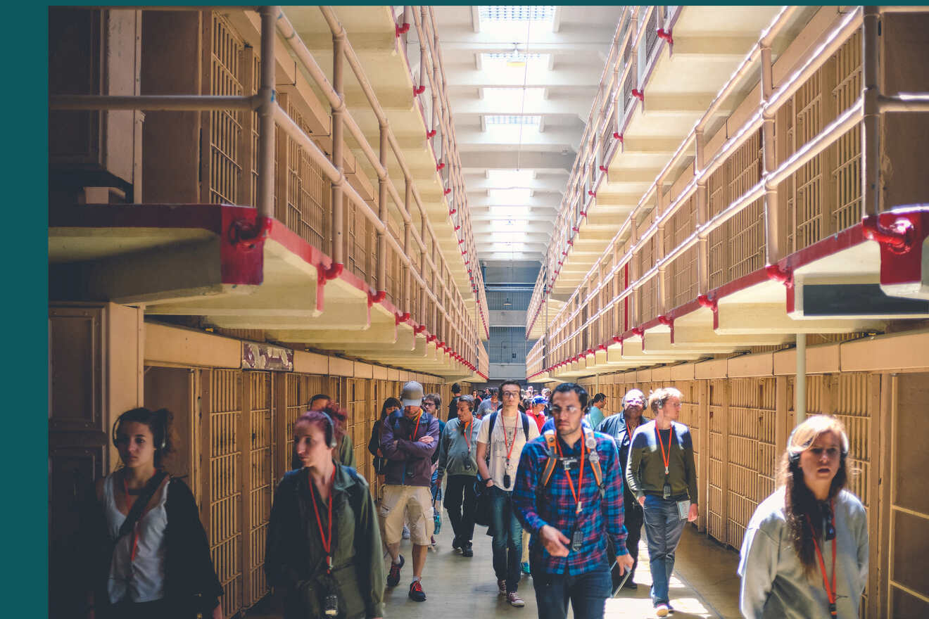 People walking past prison cells in Alcatraz 