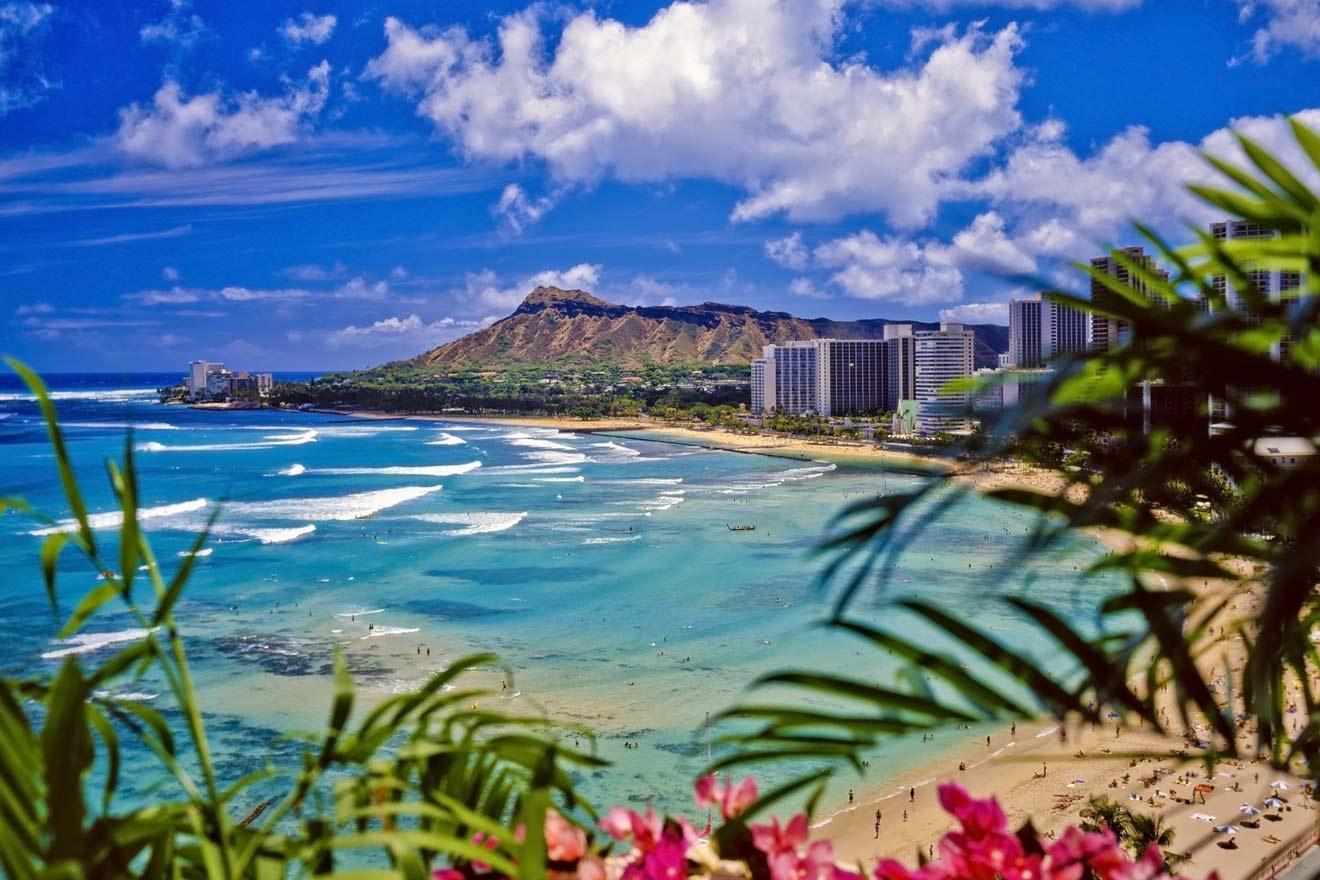 a view of a beach with buildings and volcano in the background