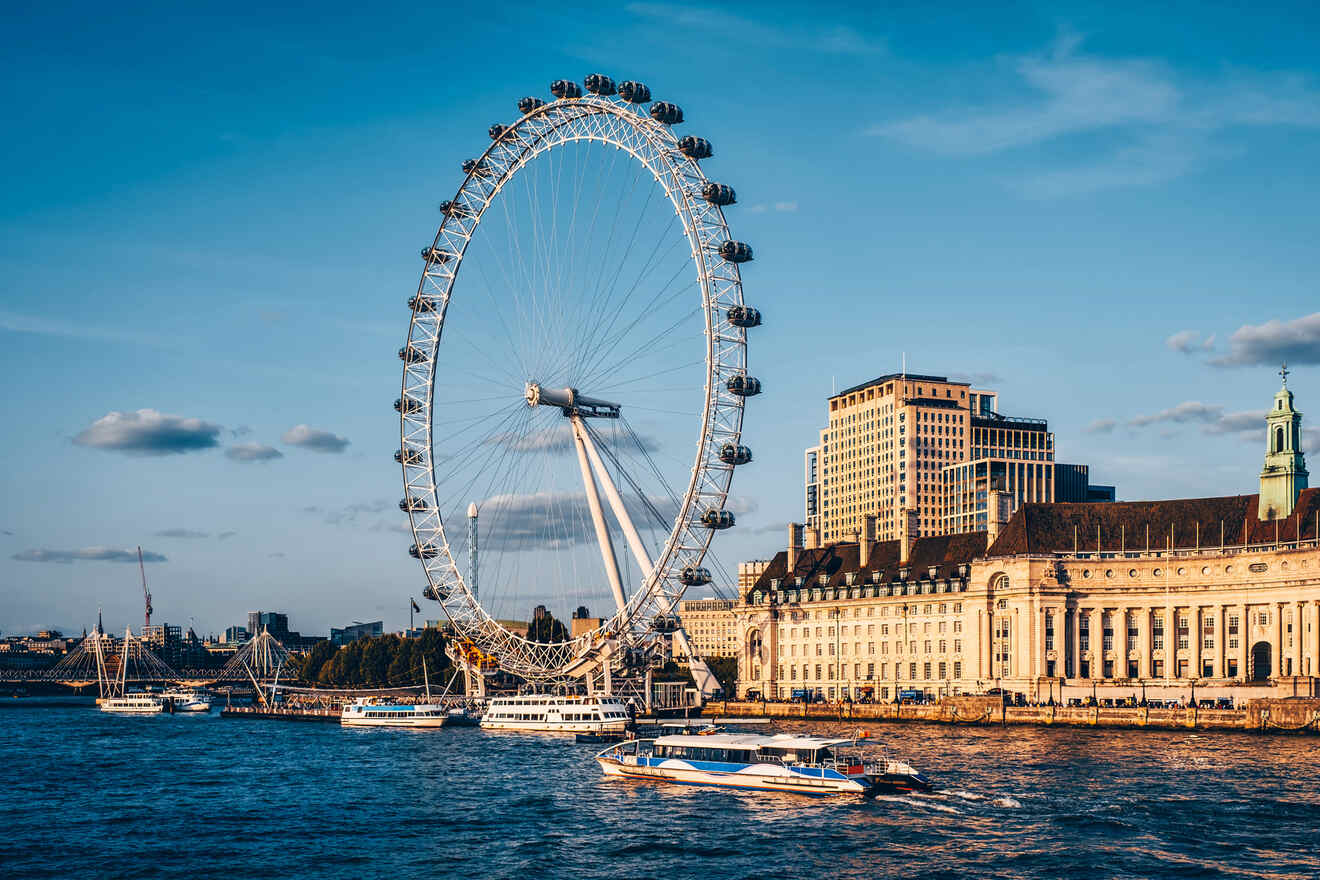 The image shows the London Eye, a large ferris wheel, on the River Thames with boats on the water and buildings in the background. It's a sunny day with a clear blue sky.