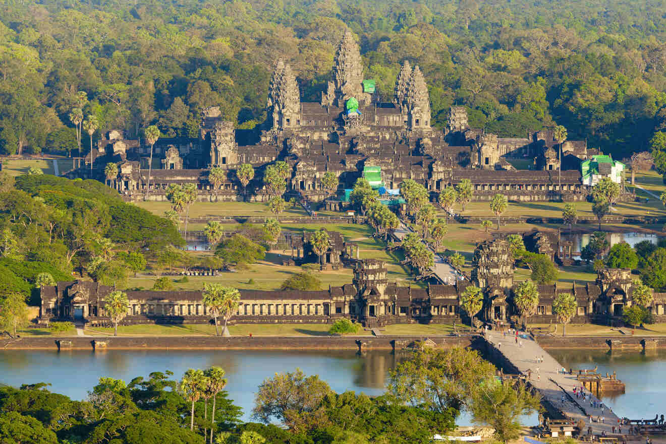 Aerial view of the majestic Angkor Wat temple complex at sunrise, reflecting in the water, symbolizing the architectural prowess of the Khmer empire in Cambodia