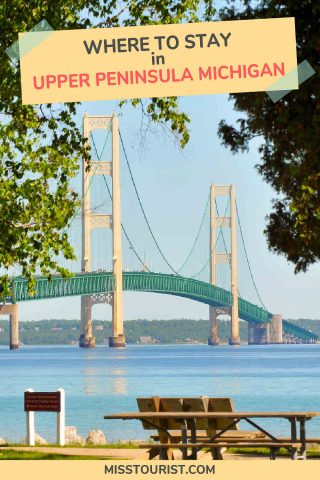 View of Mackinac Bridge spanning over blue water, with trees framing it and a picnic table in the foreground. Text reads 