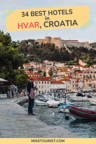 A person stands at the edge of a marina in Hvar, Croatia, with boats moored in the foreground and historic buildings and trees in the background. Text on the image reads "34 Best Hotels in Hvar, Croatia.