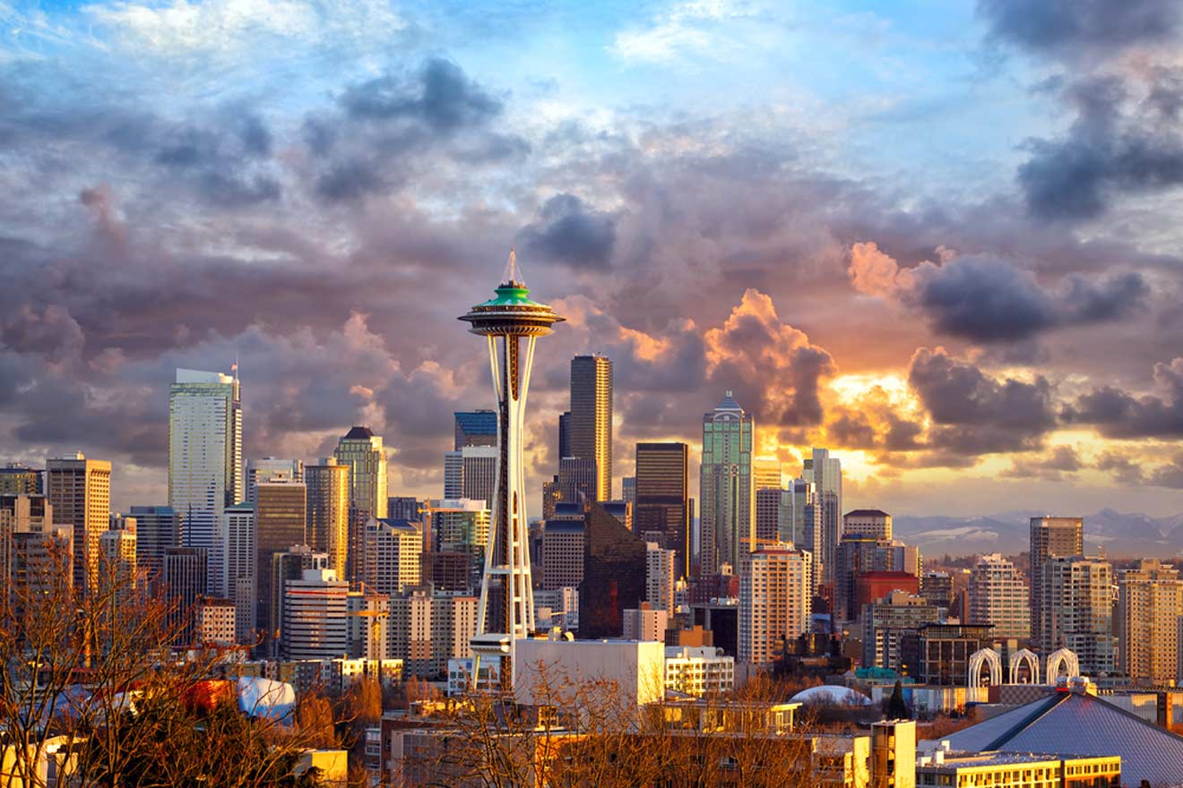 Seattle skyline at sunset with the Space Needle prominently featured against a backdrop of dramatic clouds and city buildings