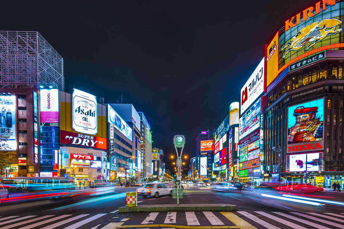 A vibrant night scene of a busy street lined with brightly lit billboards and neon signs in the city.