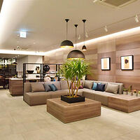 A stylish hotel lobby with modern furniture, plants, and artwork on the walls, creating a welcoming atmosphere.