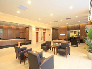 A hotel lobby with comfortable seating, modern decor, and a reception desk in the background.