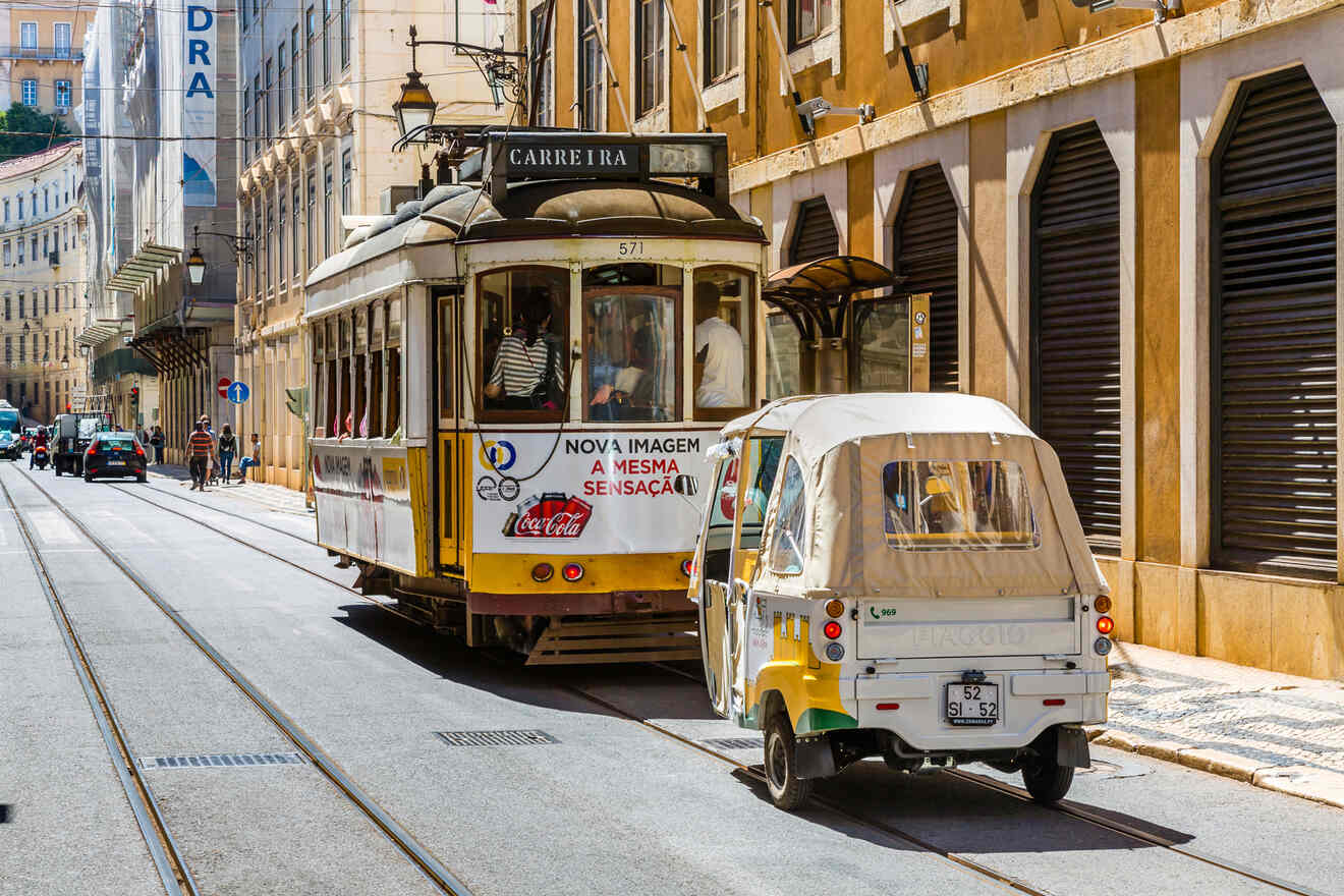 A yellow tram and a small auto rickshaw travel down a city street lined with buildings.