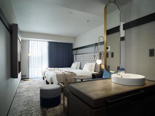  A sleek hotel room with twin beds, modern decor, and a large window allowing natural light to flood the space.