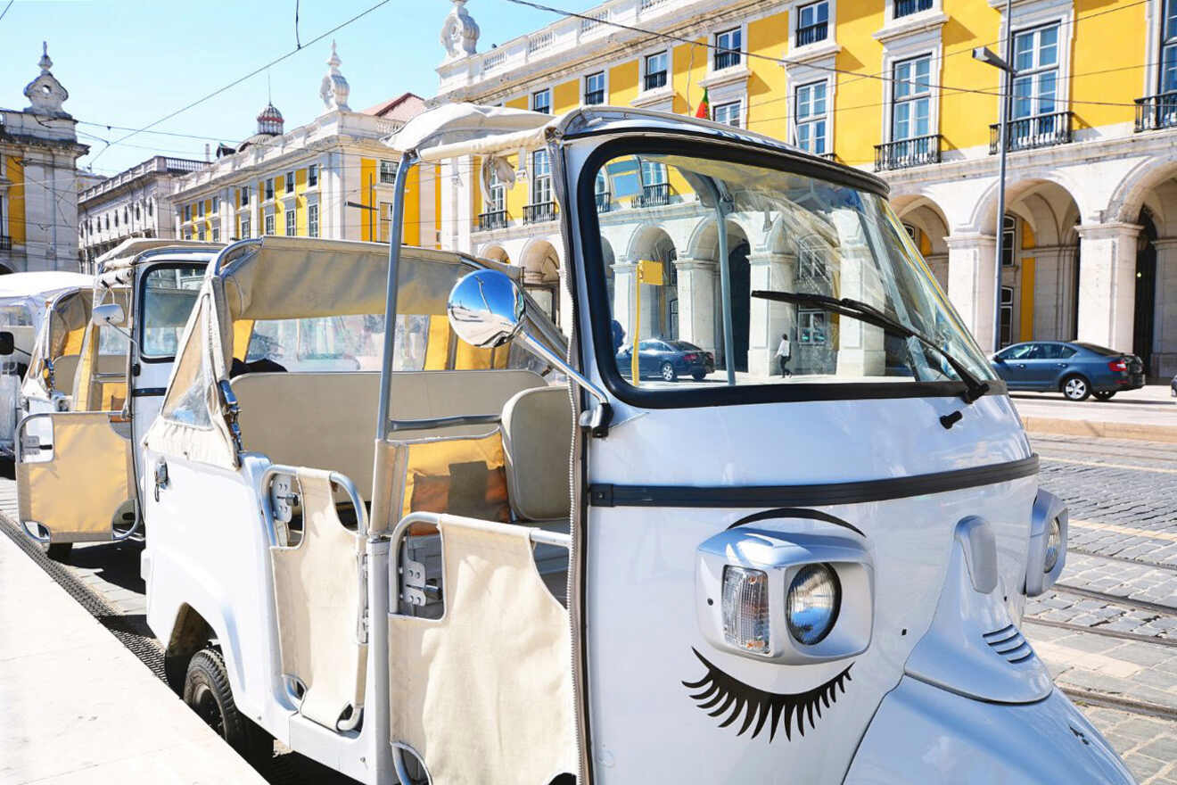 White tuk-tuk parked on a sunny street with yellow historic buildings in the background.