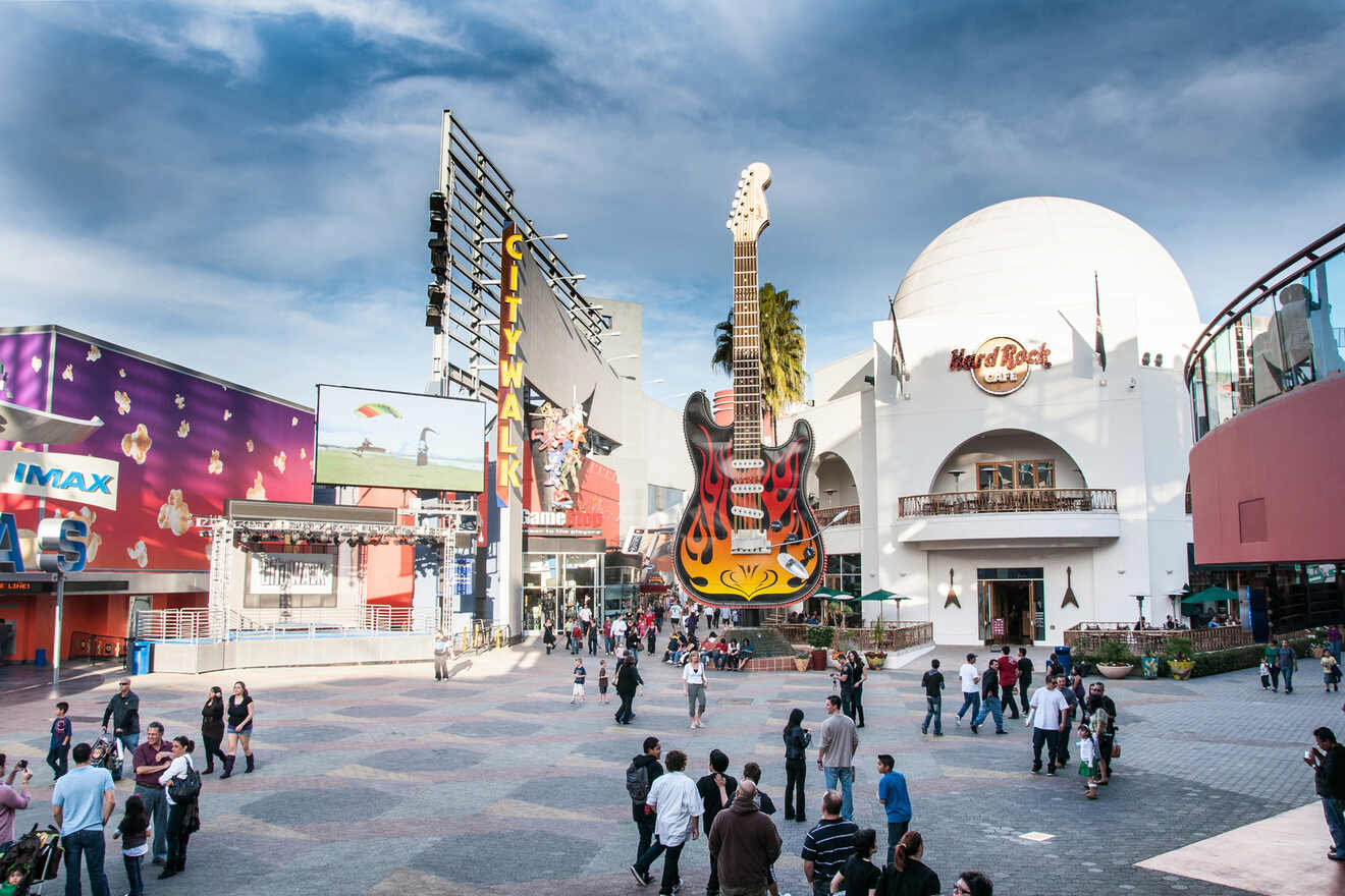 a group of people standing around a building and big guitar