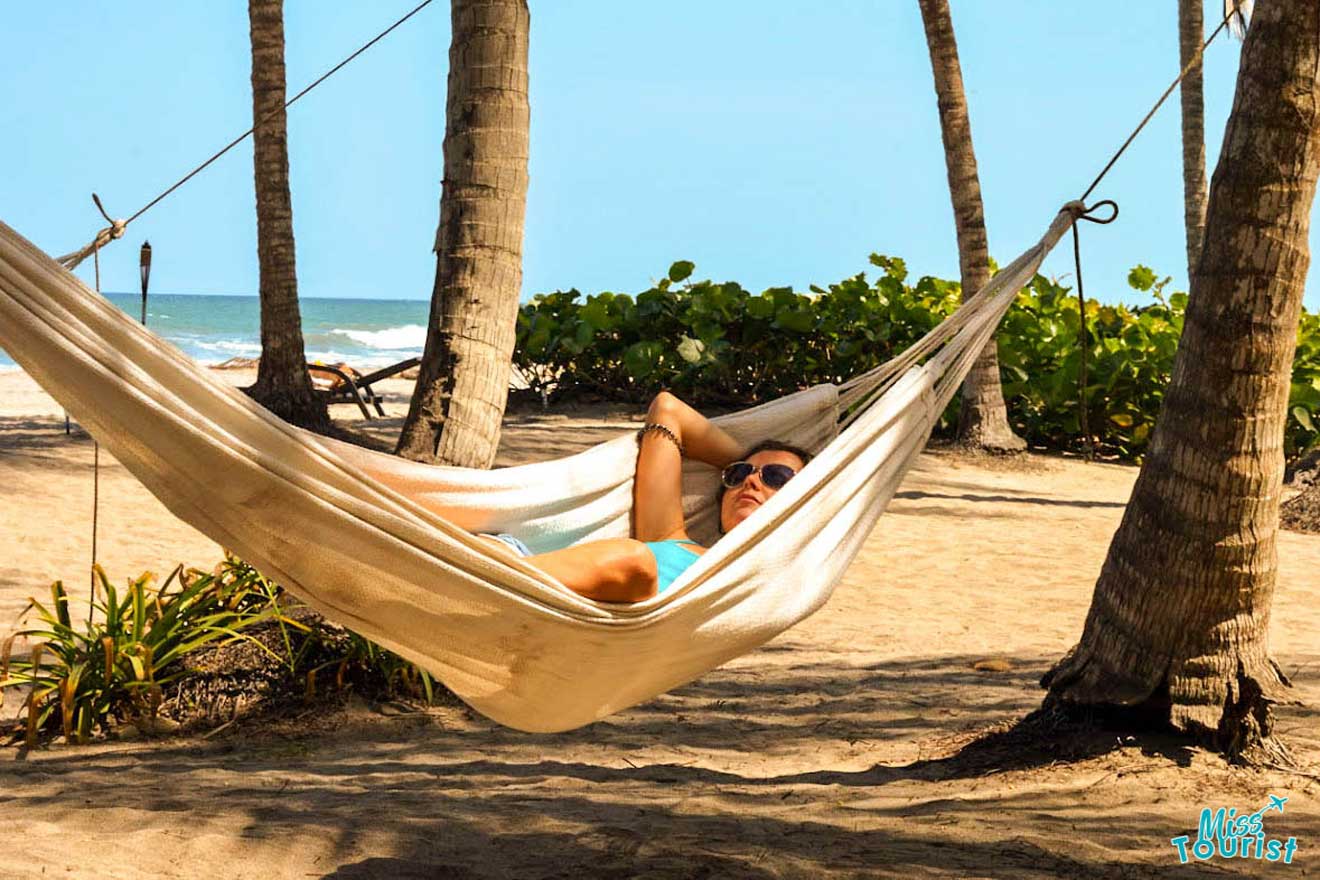 a girl lies in a hammock on the coast