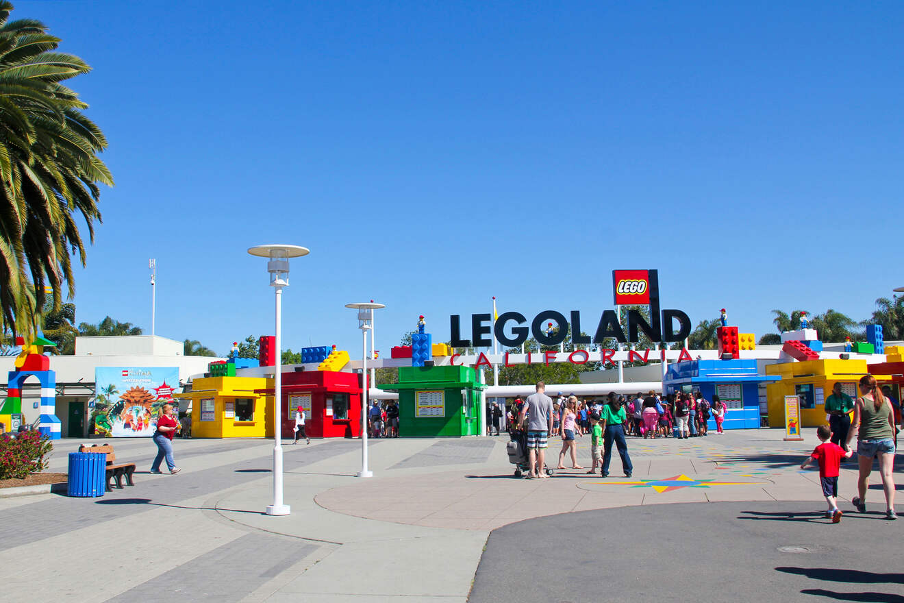 a group of people standing in front of a legoland sign
