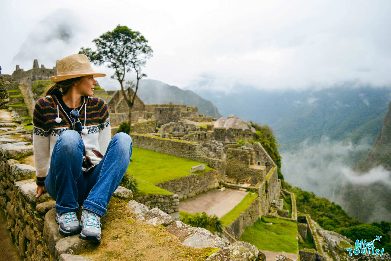 woman sitting on a wall looking at a view