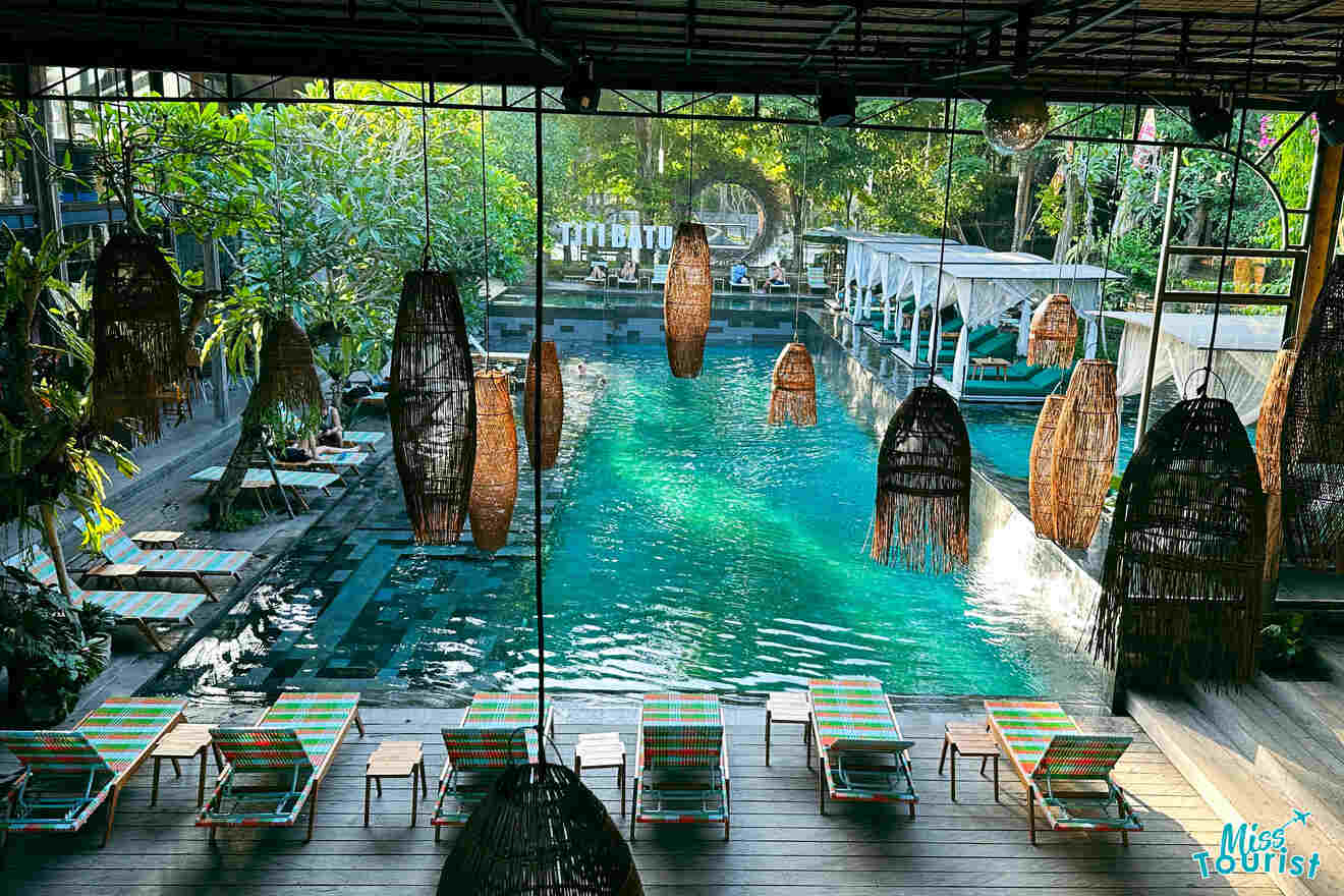 Aerial view of a pool with hanging rattan loungers and deck chairs in a serene Ubud retreat