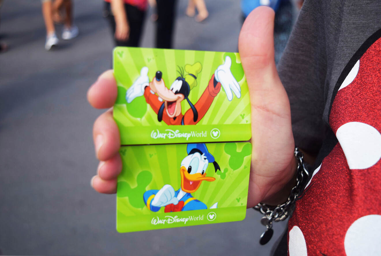 person holding Disney World tickets