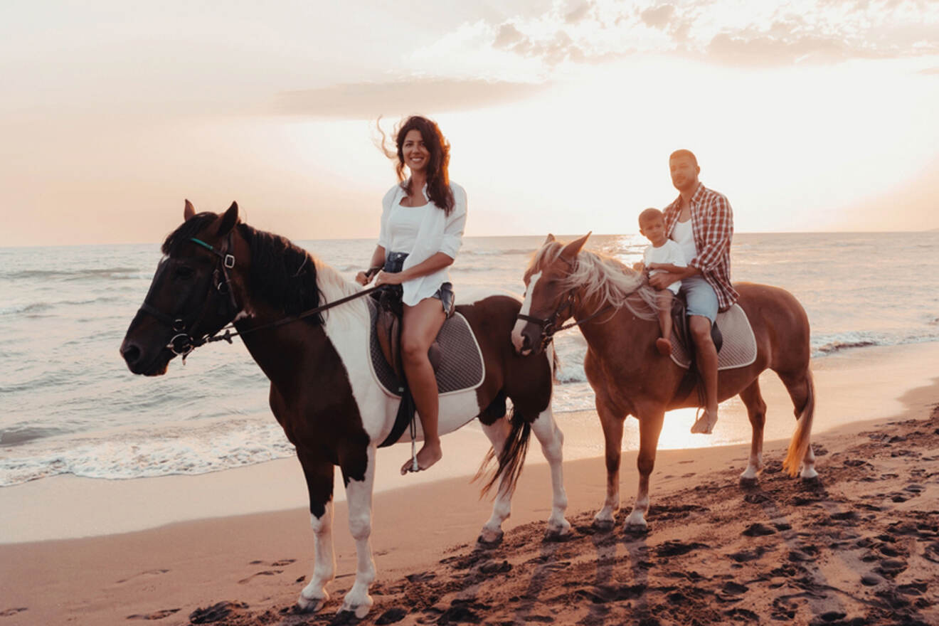 people horseback riding on the beach