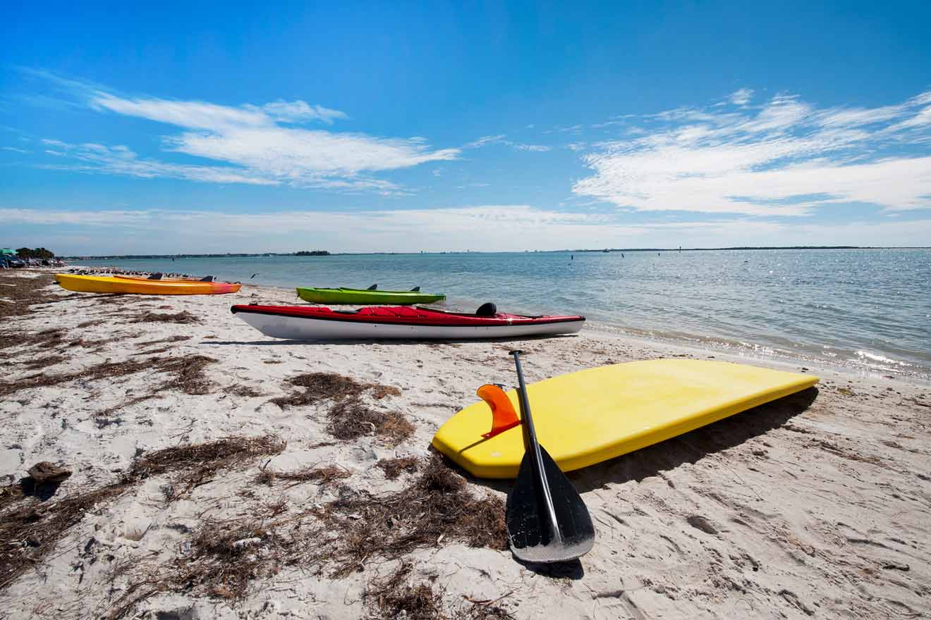 Kayaks and a surf board on a sandy beach
