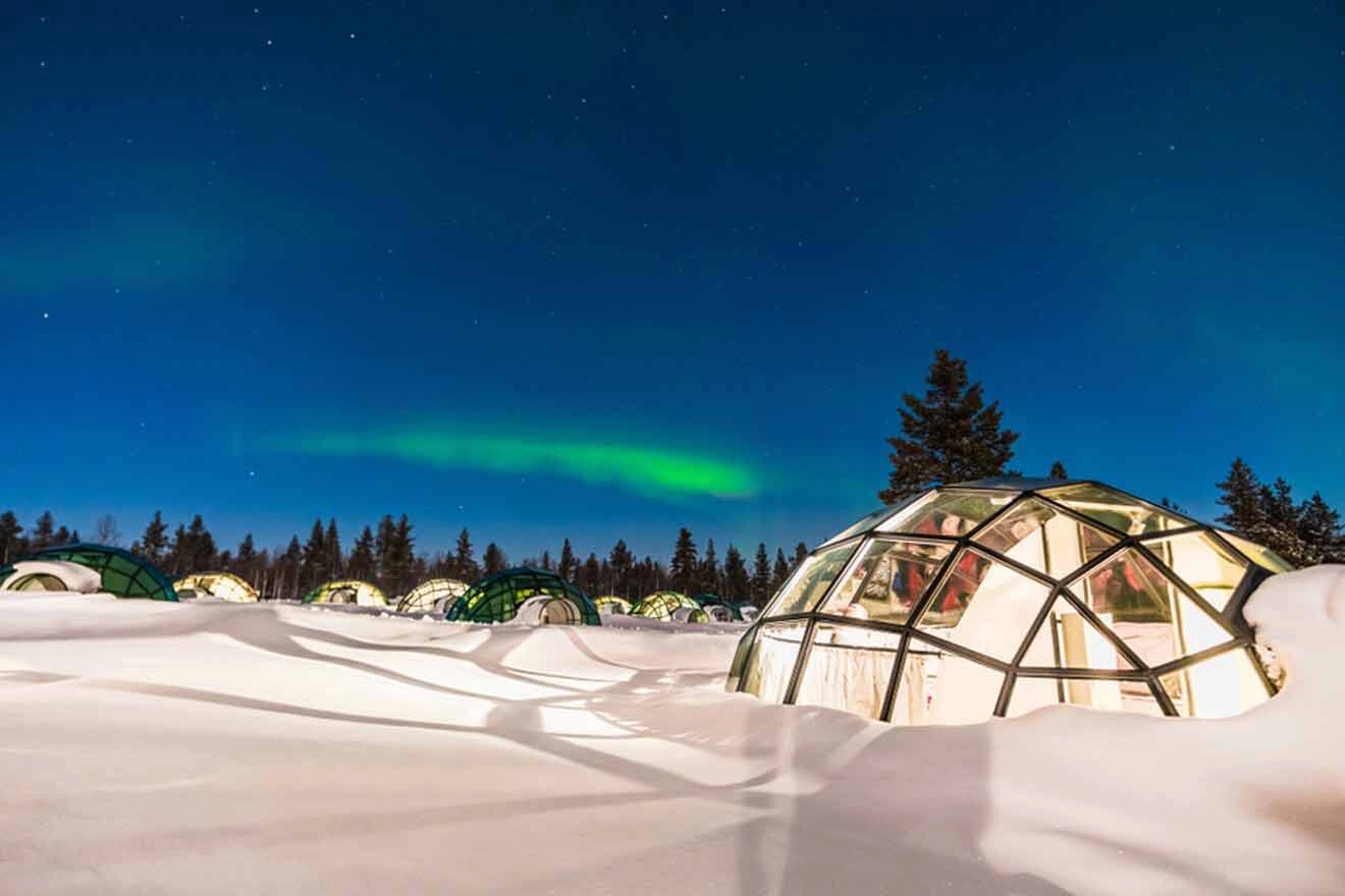 various glass igloos at night with the northern lights