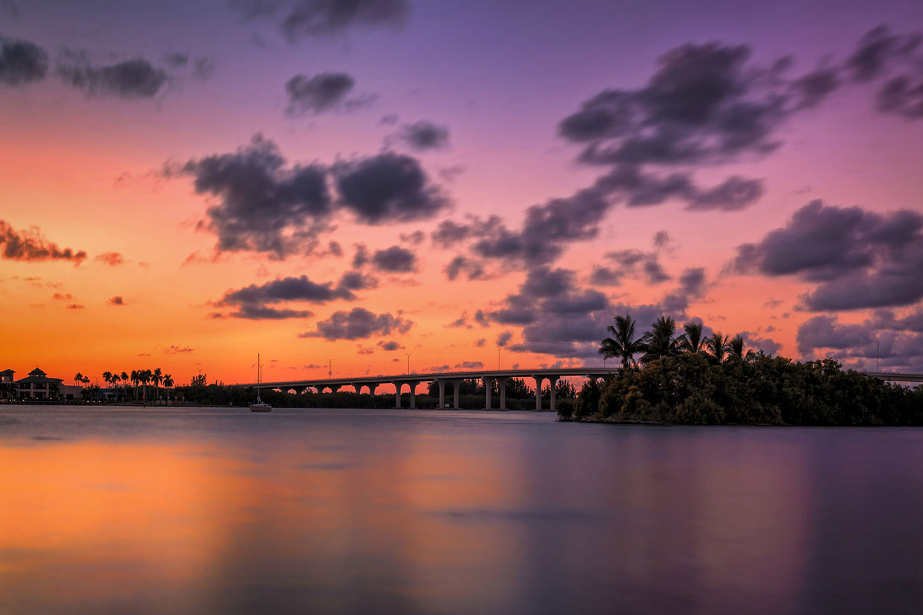 a bridge over the water at sunset