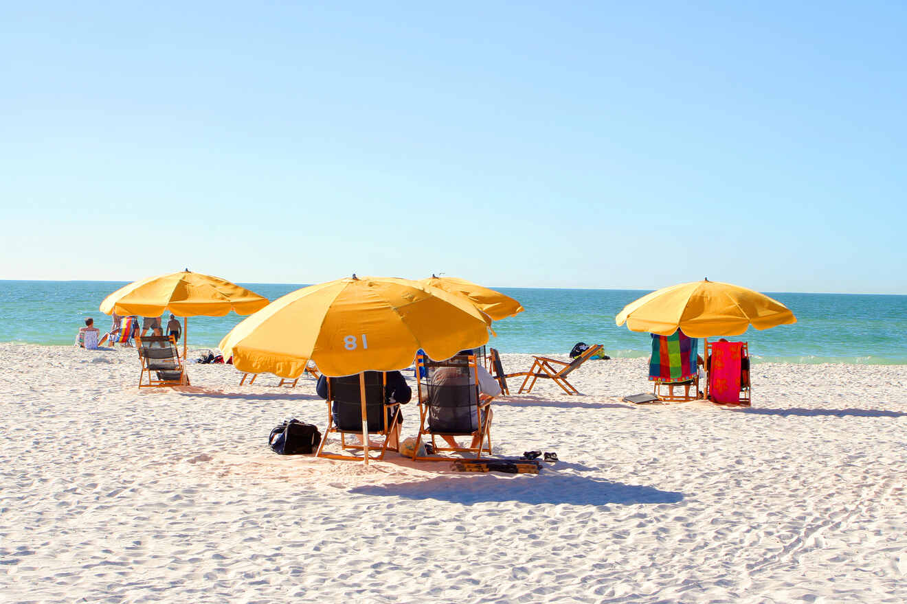 people on the beach sitting on chairs underneath umbrellas