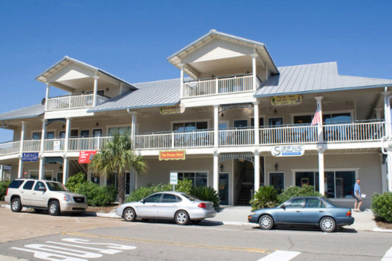 building with various shops and parked cars 