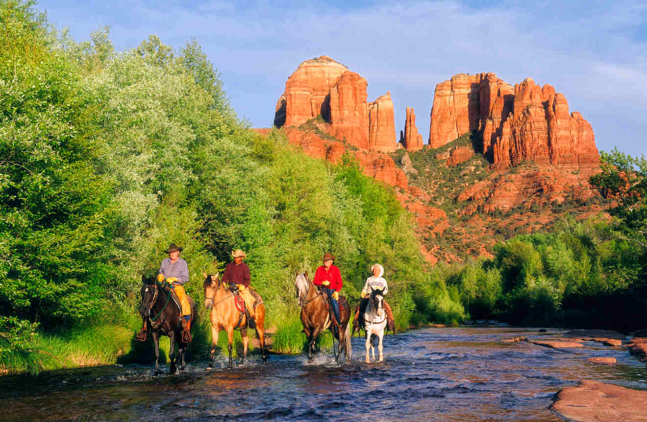 People riding horses in the rivers near the rocks in Sedona