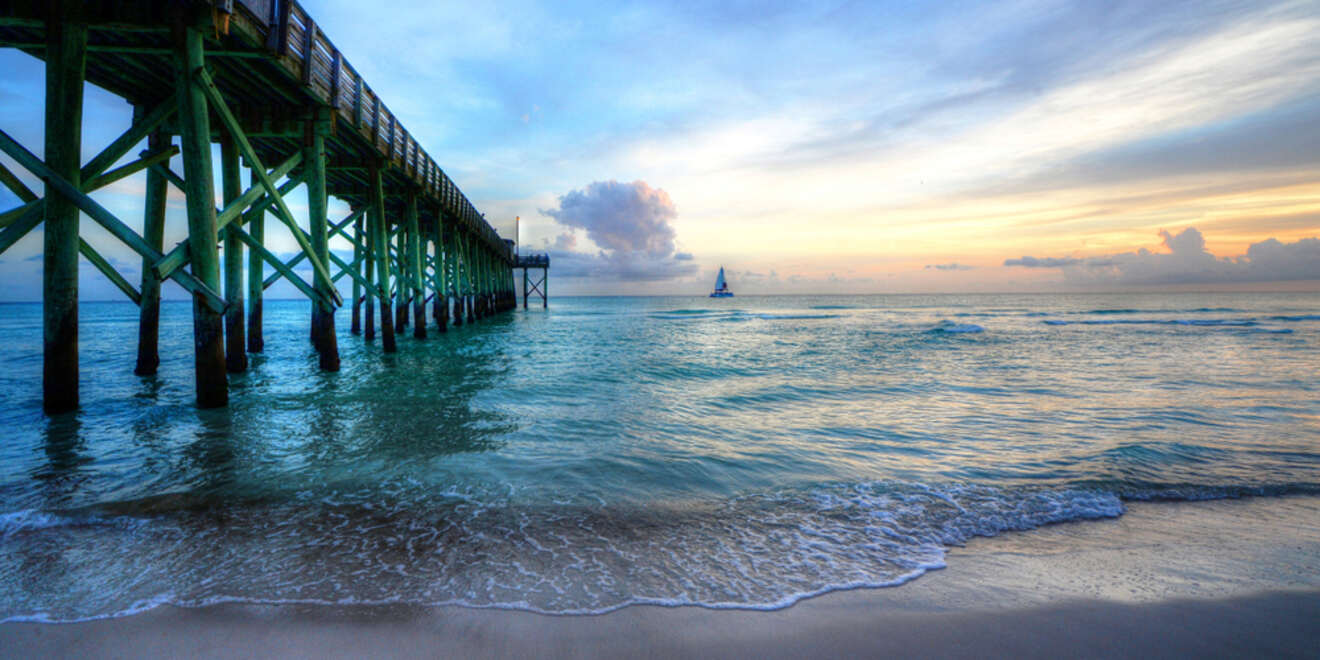 View of a sailboat next to the pier at sunset