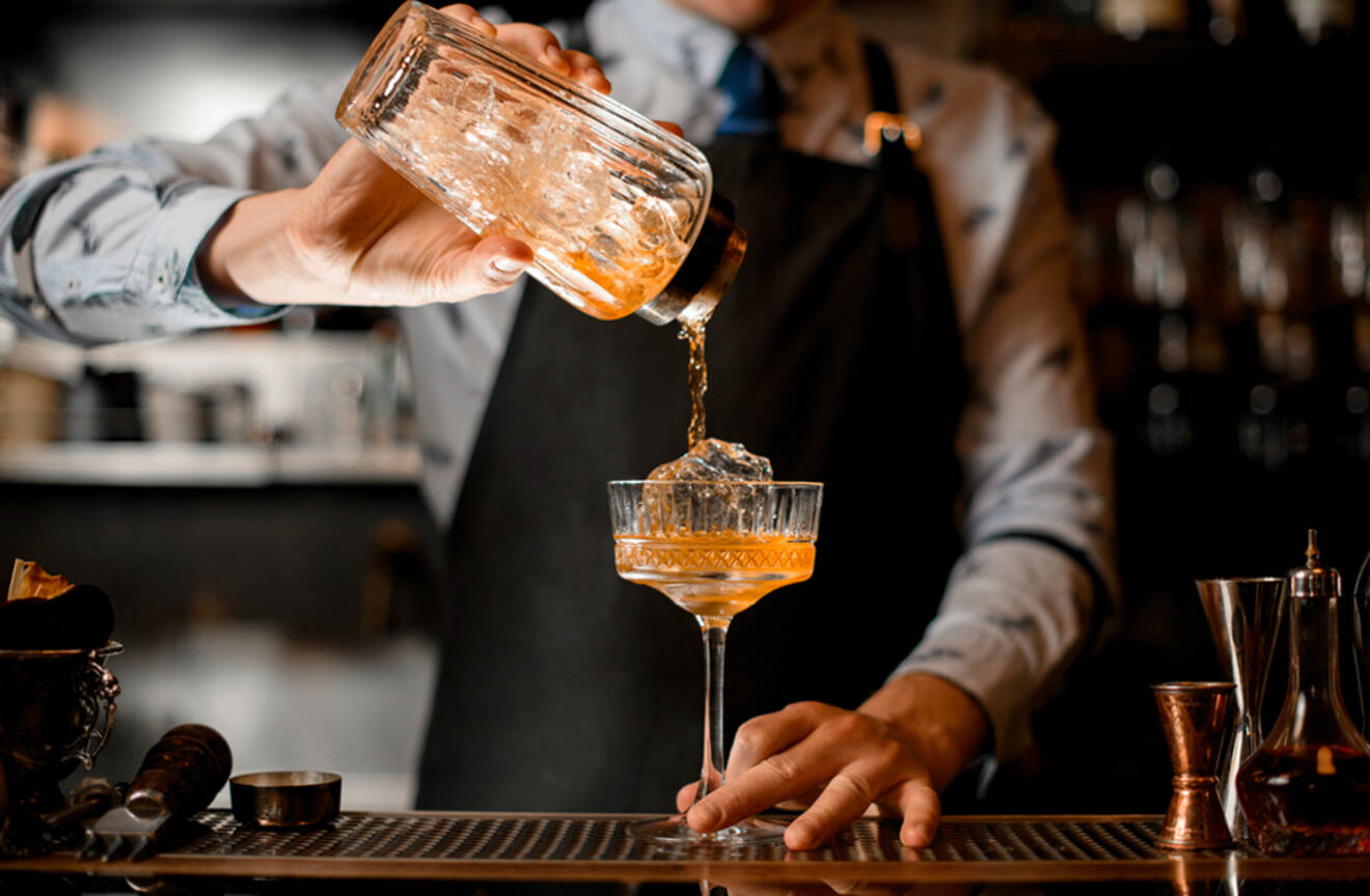 Bartender pouring cocktail in a glass