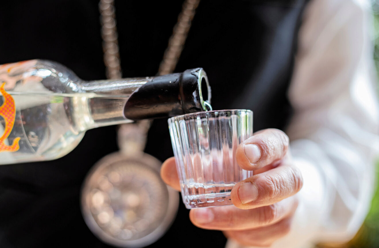 Closeup of a person pouring mezcal in a glass