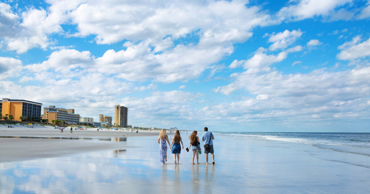 group of friends walking on the beach