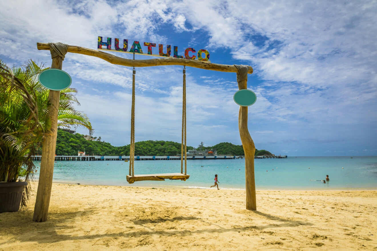 Swing at the beach with a Huatulco sign