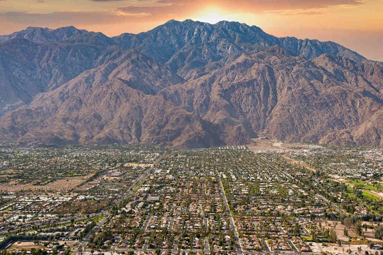 an aerial view of a city with mountains in the background