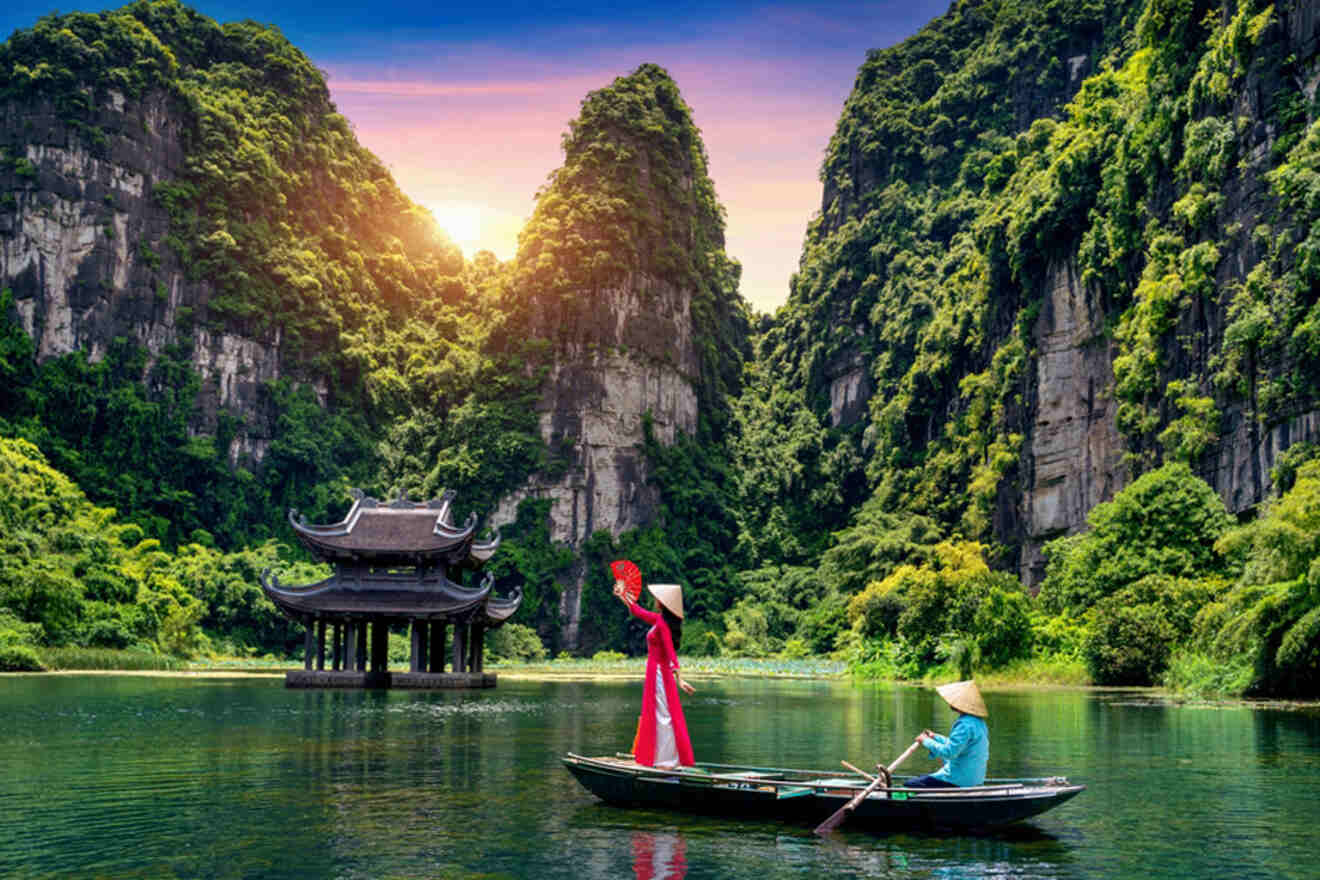 Asian woman wearing cultural dress at Trang An Vietnam on a boat