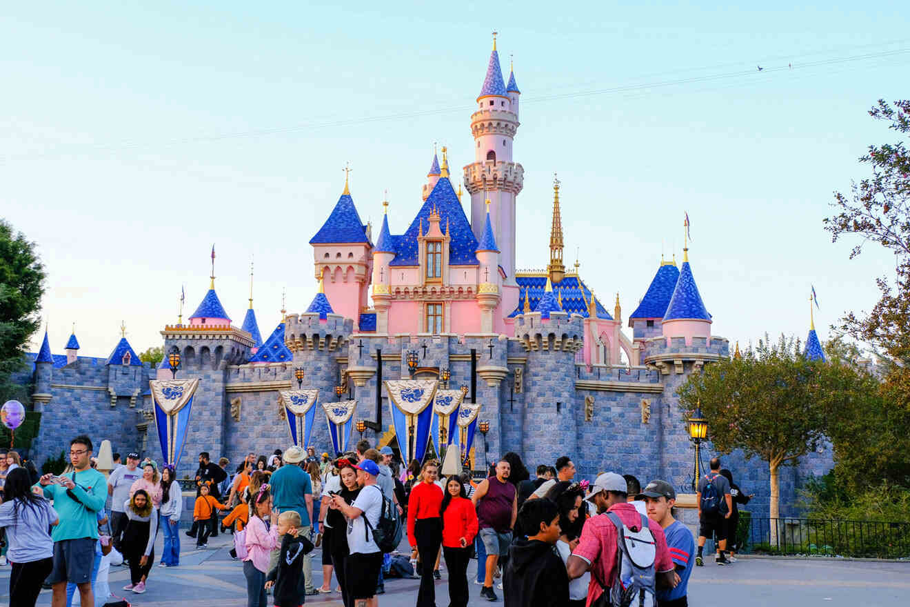 a group of people standing in front of Sleeping Beauty Castle at Disneyland in Anaheim