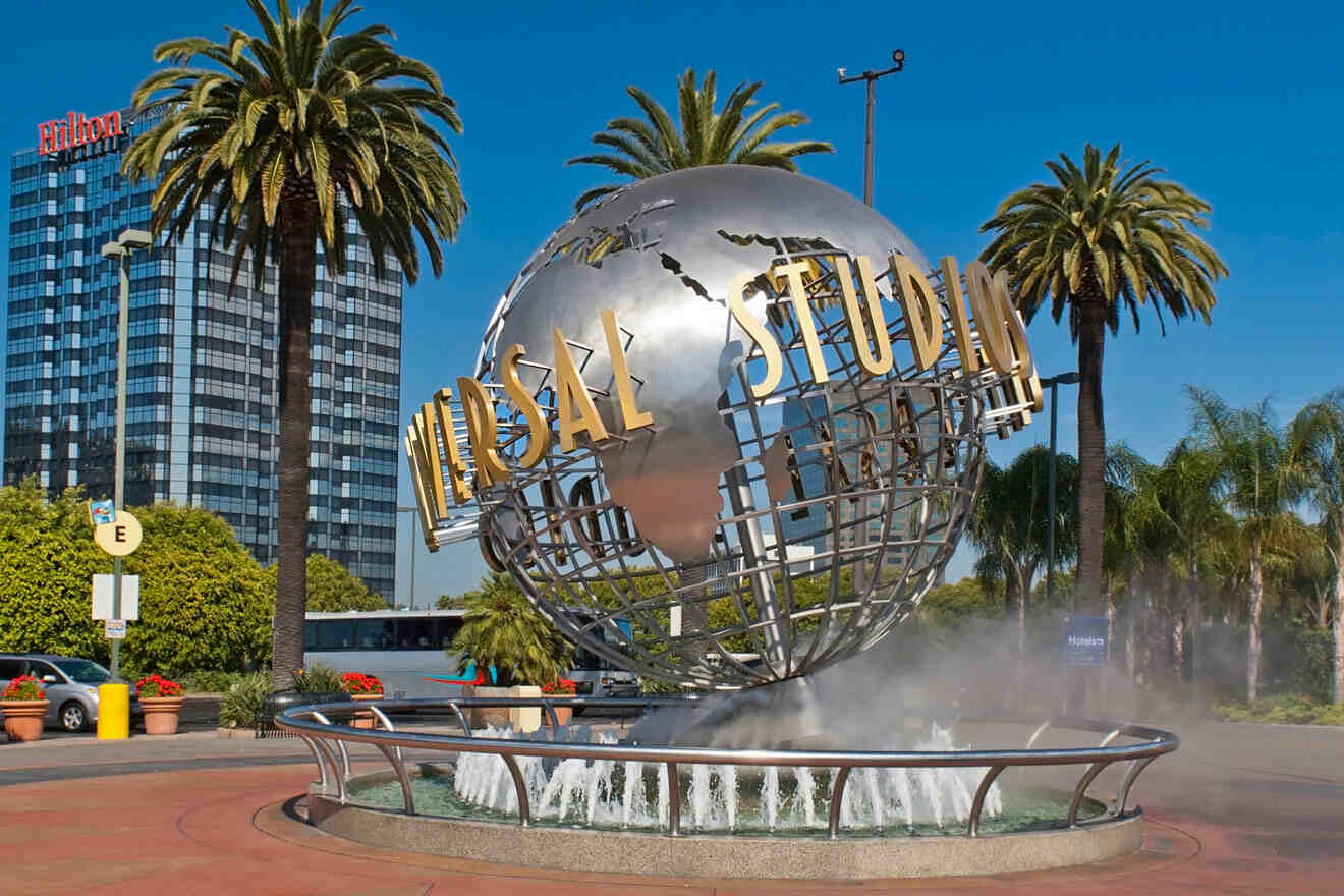 a large metal globe with a fountain in front of it