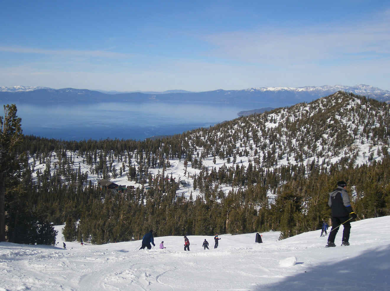 View of people skiing on a mountain view a view over lake