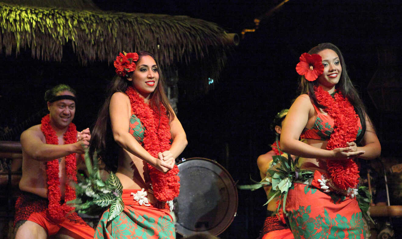 Women in traditional wear dancing at a luau