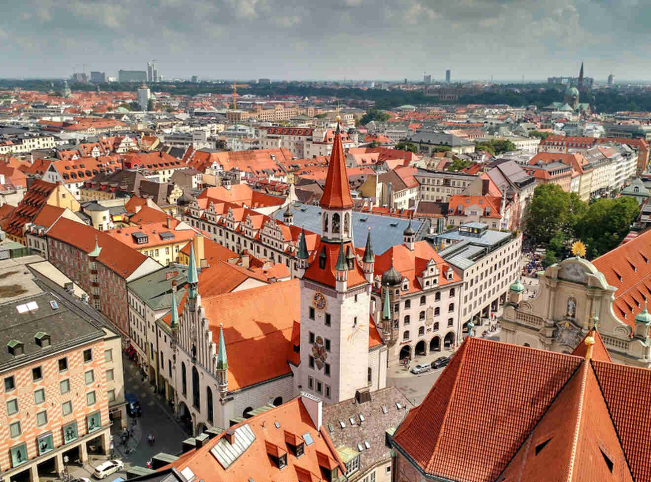 an aerial view of a city with red roofs and church in Munich city center