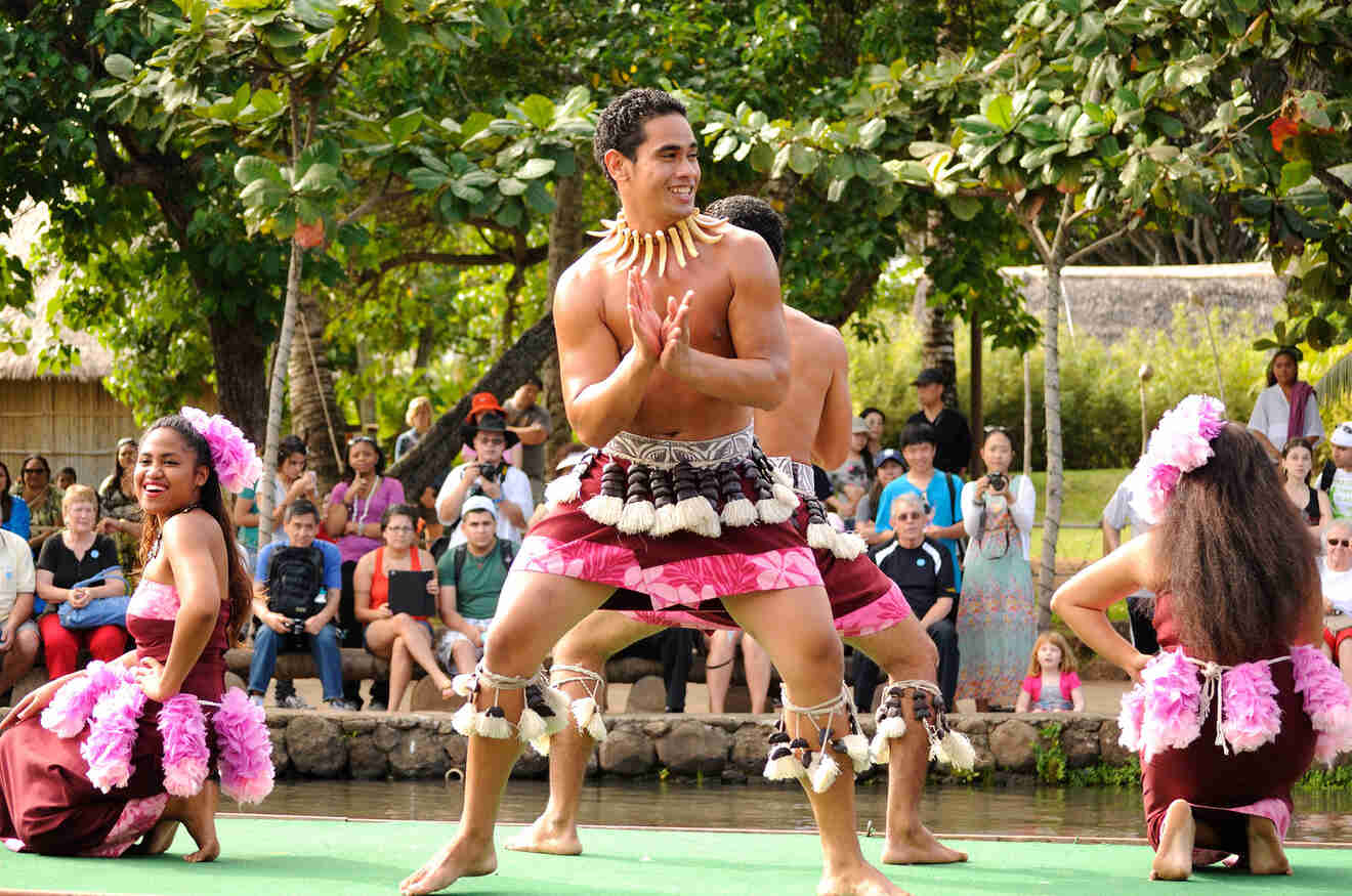 Men and women in traditional wear dancing at a luau