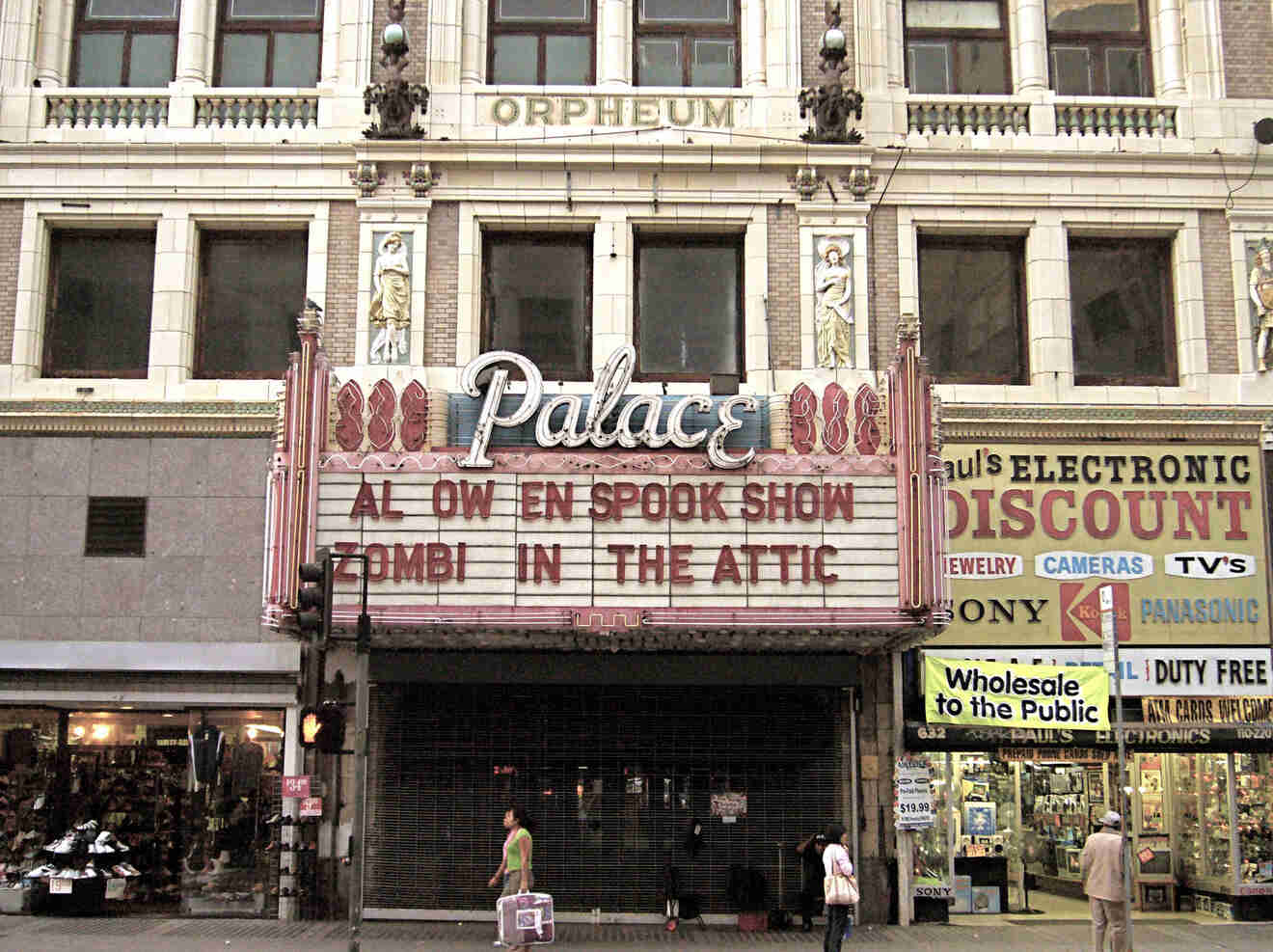 a movie theater with people standing in front of it