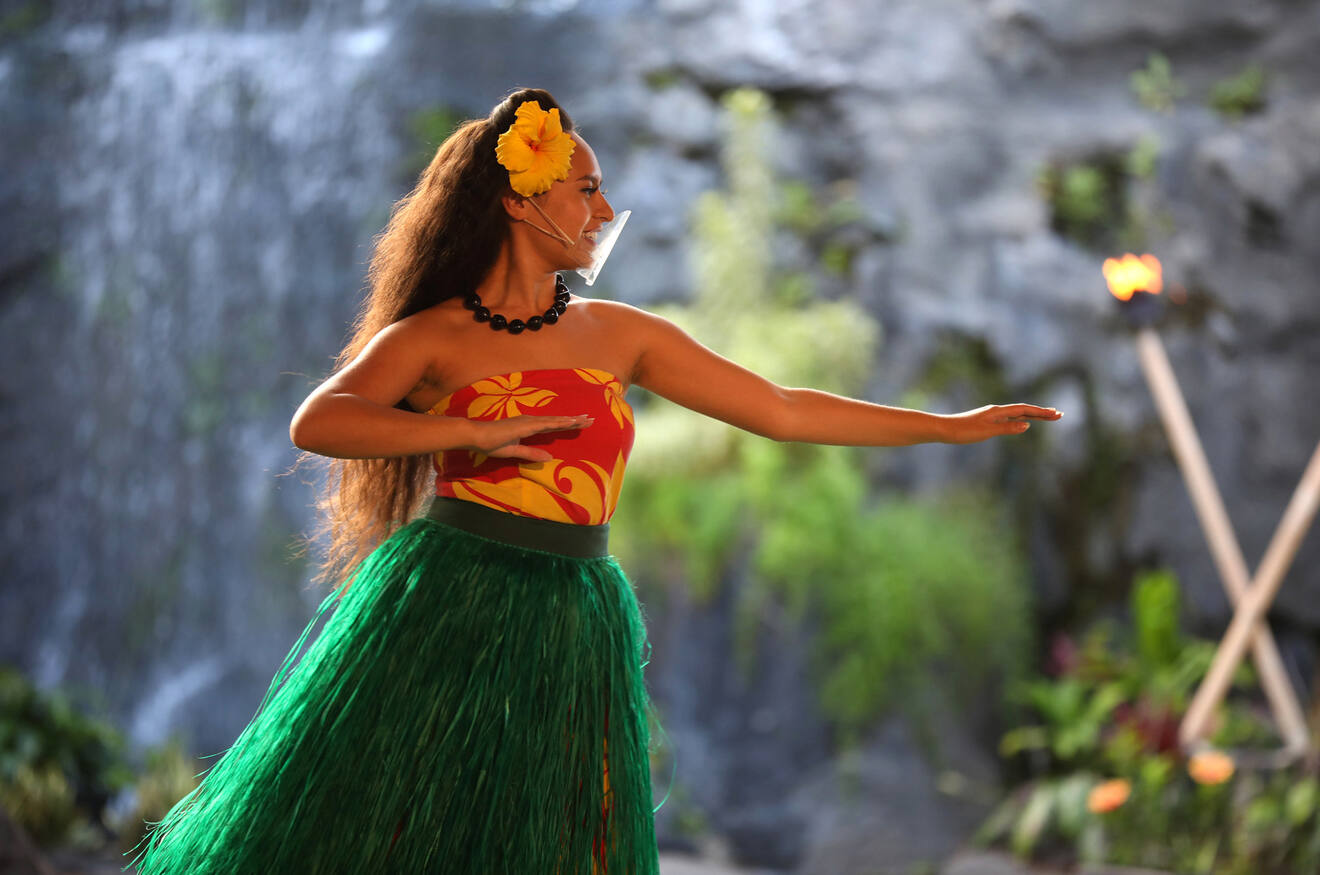Woman in Hawaiian dress dancing at luau
