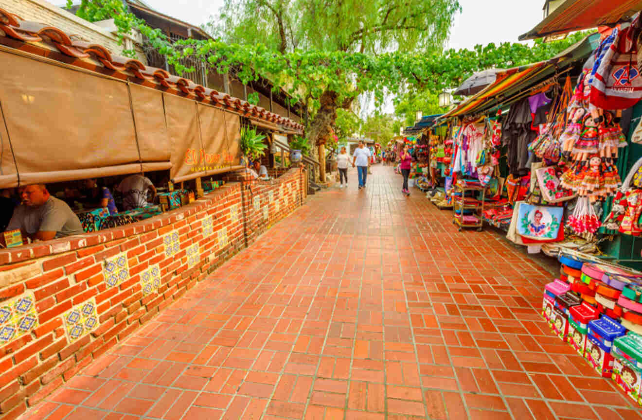 a narrow brick street lined with shops and vendors