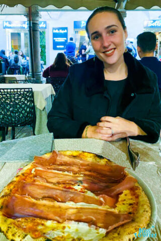 A girl eating pizza in Pavia