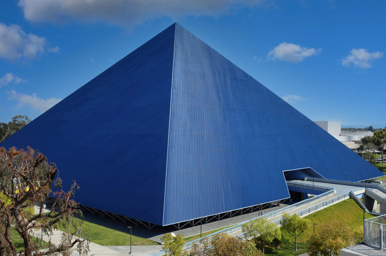 a large blue pyramid shaped building in a park